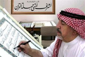 استاد عثمان طاها در حال کتابت قرآن.jpg
